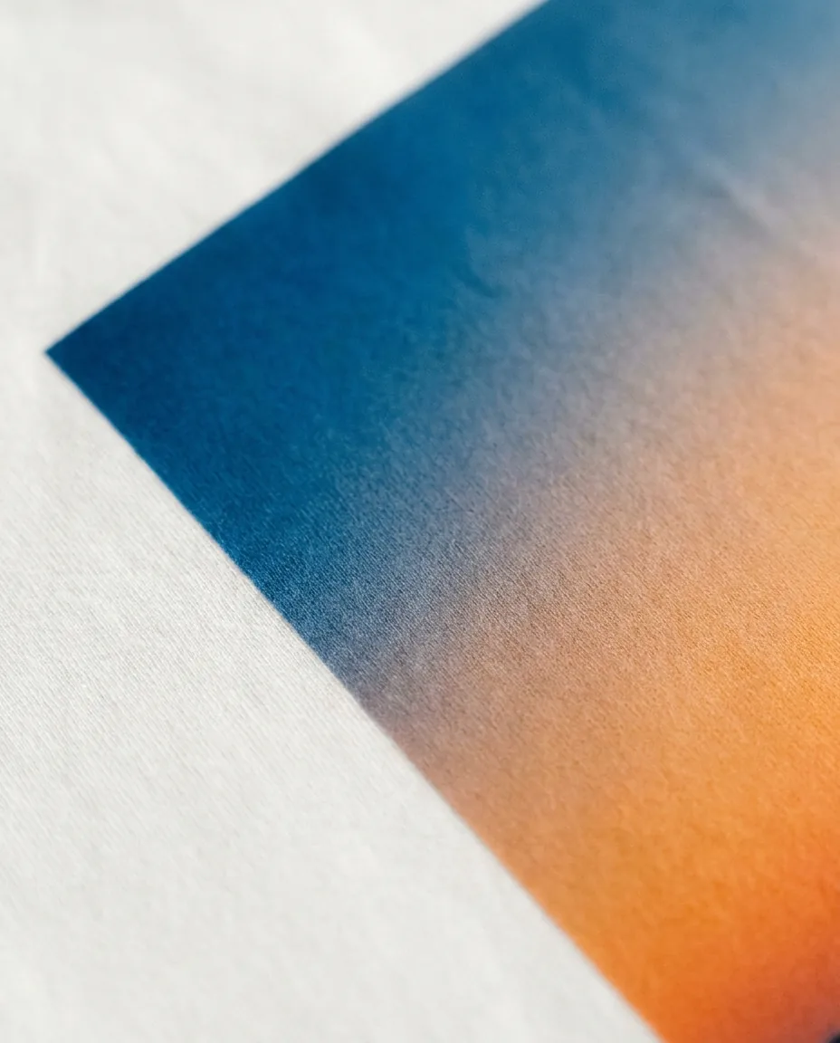 Detalle macro de transfer DTF en camiseta con degradado visible y borde limpio a alta resolución