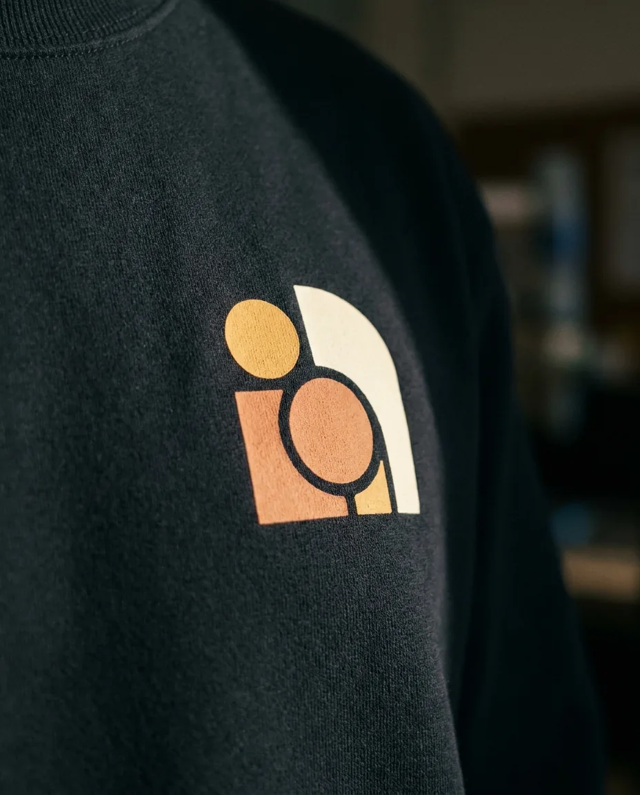 Detalle macro de logo DTF aplicado en pecho de sudadera corporativa con textura premium del tejido visible